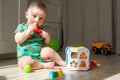 Eight-nine month baby boy plays on the floor