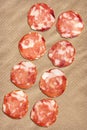 Eight Pork Salami Slices Set On Crumpled Striped Manila Brown Kraft Paper