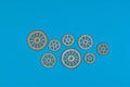 Eight wooden gears on blue surface illustrate mechanical interconnectivity Royalty Free Stock Photo