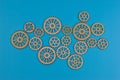 Eight wooden gears on blue surface illustrate mechanical interconnectivity, motion transfer, and design variation in engineering Royalty Free Stock Photo