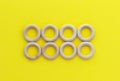 Eight wooden rings on yellow background. Natural wood baby teether. Eco-friendly children toy. Top view, flat lay