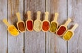 Eight wooden spoons of asian spices on wooden table