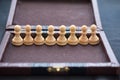 Eight wooden white pawns of the chess game in a vintage box