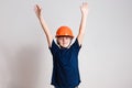 Eight-year-old boy in orange helmet working on white background