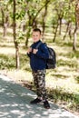 Eight-year-old schoolboy in a large backpack on his back in full height