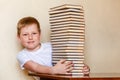 An eight-year-old smiling child and a big stack of books. children and reading Royalty Free Stock Photo