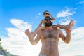 Eight years old boy sitting on dad`s shoulders. Both in swimming shorts and sunglasses, having fun on the beach. Bottom view