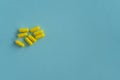 Eight yellow tablets in the form of capsules on a blue background. Medical concept. medicine pills, Pharmacy theme