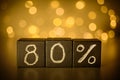 80% eighty percent sign chalk written on black cubes on blurred bokeh background