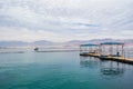 On water pavilions and wooden walkways with sitting inside tourists in famous Dolphins beach in Eilat, Israel