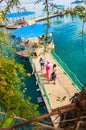 On water pavilions and wooden walkways with sitting and walking tourists in famous Dolphins beach in Eilat, Israel