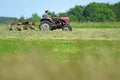 An old tractor turning hay