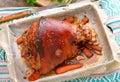 Eisbein with wegetables on a baking sheet.