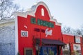 EL Bandido Mexican Grill and The Honey Pot in an orange buildings surrounded by lush green plants and bare winter trees