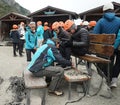 Mountain guides help tourists place crampons before ice trekking on Perito Moreno Glacier