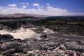 El Cotillo - Faro del Toston: View over black volcanic rocks and lagoon on village from beach La Concha north Fuerteventura Royalty Free Stock Photo