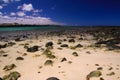 El Cotillo, North Fuerteventura: View over bright scattered stoneson beach in shallow water on turquoise lagoon of beach La Concha