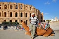 A local tunisian posing with his camel in front of the impressive Roman amphitheater of El Jem