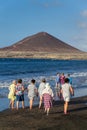 Senior local women walking on Playa El Medano beach during sunrise in El Medano