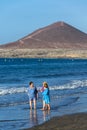 Senior local women walking on Playa El Medano beach during sunrise in El Medano