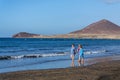 Senior local women walking on Playa El Medano beach during sunrise in El Medano