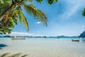 El Nido, Palawan island, Philippines. Palm trees of Corong Corong beach, island hopping boats in blue shallow lagoon and blue sky Royalty Free Stock Photo