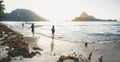 Kids watching and playing at the beach during sunset at the karst mountain island El Nido, Philippines