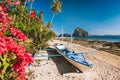 El Nido, Palawan, Philippines. Native banca boat and vibrant flowers at Las cabanas beach with amazing Pinagbuyutan island in Royalty Free Stock Photo