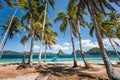 El Nido, Palawan, Philippines. Palm trees on sandy beach. tourist filippino banca boat in turquoise ocean lagoon. Island hopping Royalty Free Stock Photo