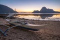 El Nido, Palawan, Philippines. Traditional fishing banca boat on shore. Cadlao Island in sunset light in background Royalty Free Stock Photo
