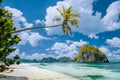 El Nido, Palawan, Philippines. Tropical scenery of exotic beach with palm tree, boat on the sandy beach and blue sky Royalty Free Stock Photo