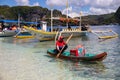 El Nido, Philippines - 20 Nov 2018: sea landscape with tourist boat and food seller in kayak. Streetfood vendor on beach
