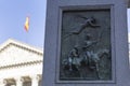 El quijote de la mancha book scene high relief into a stone pillar at madrid square with spanish flag