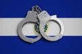 El Salvador flag and police handcuffs. The concept of observance of the law in the country and protection from crime