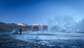 Beautiful image of a girl walking through salt deposits with big vapour columns in the background. Taken at the sunrise in Geysers
