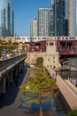 El train crossing Chicago River while commuters walk riverwalk Royalty Free Stock Photo