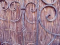 Elaborate ornamental wrought Iron fence against reeds wall Royalty Free Stock Photo