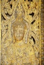 Elaborate wood carved wooden door at Wat Pa Huak temple in Luang Prabang, Laos.
