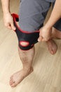 Elastic bandage to fixate knee, prevent injuries of sore knee joint, hands are pressed to fix it