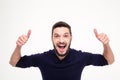 Elated excited young happy man shouting and showing thumbs up