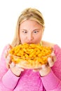 Elated woman with large bowl of unhealthy crisps Royalty Free Stock Photo