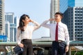 Elbow bump is new novel greeting to avoid the spread of coronavirus. Two Asian business friends meet in front of office building. Royalty Free Stock Photo