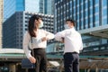 Elbow bump is new novel greeting to avoid the spread of coronavirus. Two Asian business friends meet in front of office building. Royalty Free Stock Photo