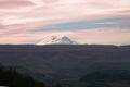 Elbrus Mountain Peak in Caucasus, Russia. White snowy mountain under colorful sky, dark valley at the bottom. Panoramic sunset vie Royalty Free Stock Photo