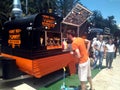 A man watching the tasty hamburger goods shown at a show case of a orange food truck