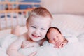 Elder brother and newborn baby sister lying on bed at home Royalty Free Stock Photo