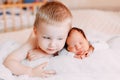 Elder brother and newborn baby sister lying on bed at home Royalty Free Stock Photo