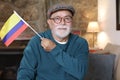 Elder Colombian citizen waving the national flag