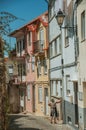 Elder in front of colorful houses on cobblestone alley