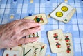 Elder hands playing cards on a blue table Royalty Free Stock Photo